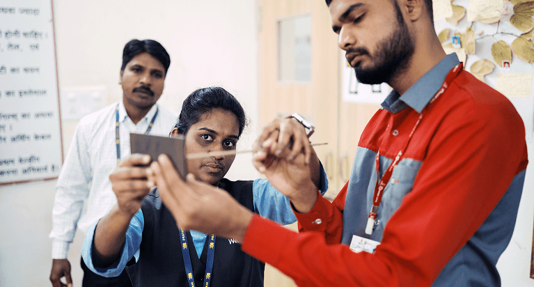 An Indian woman being mentored on vocational skills and technical materials by a professional trainer